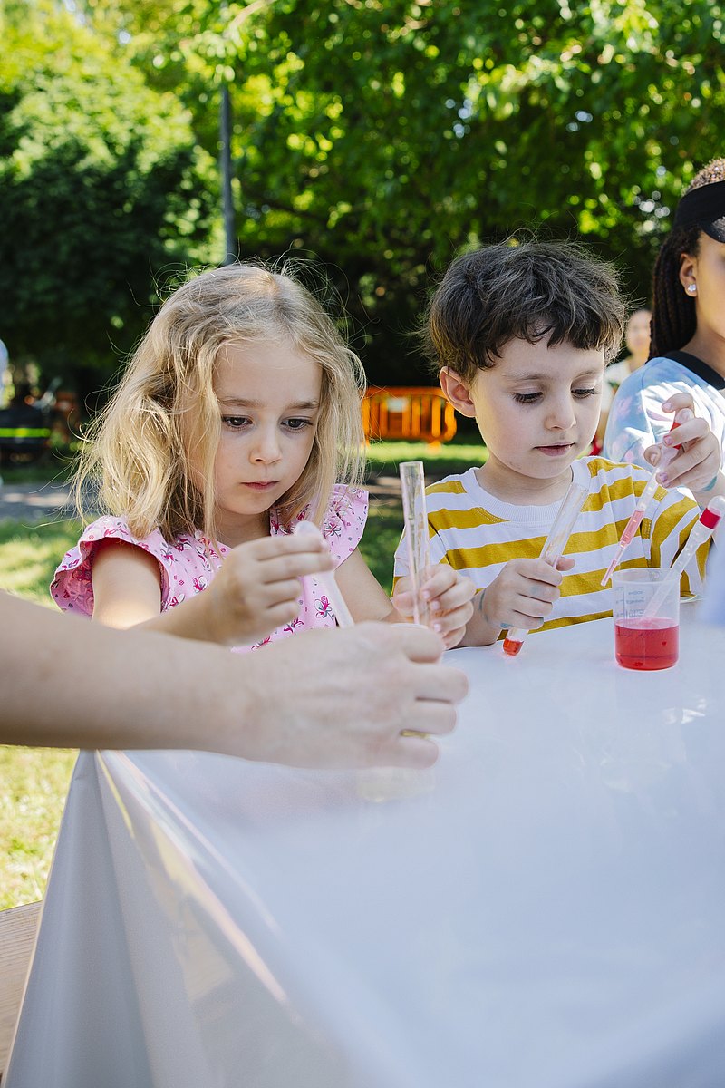 Kinder machen Experimente und arbeiten mit Reagenzgläsern